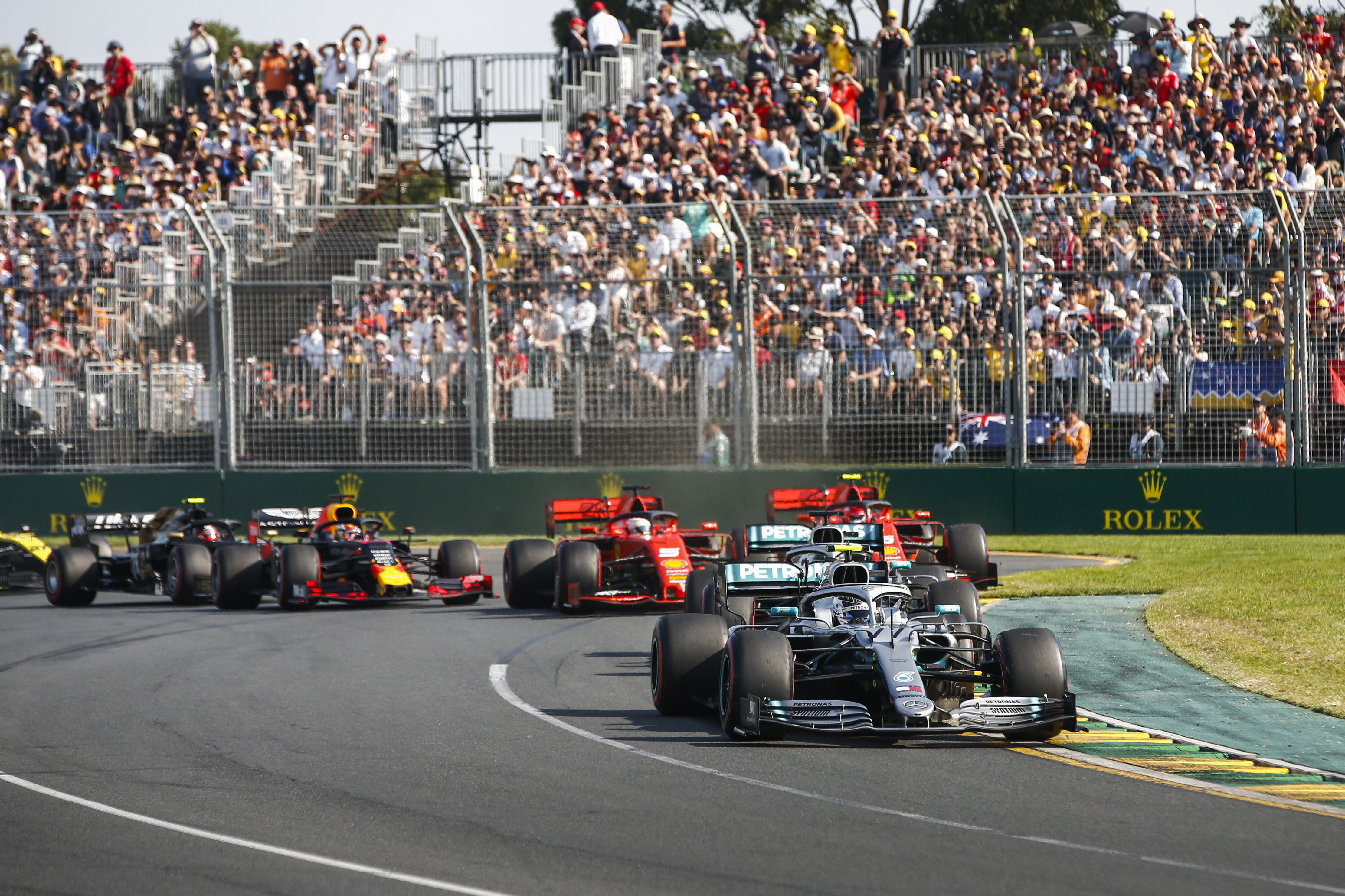 Formula 1 Grand Prix cards racing on the racing track in front of a grandstand full of people