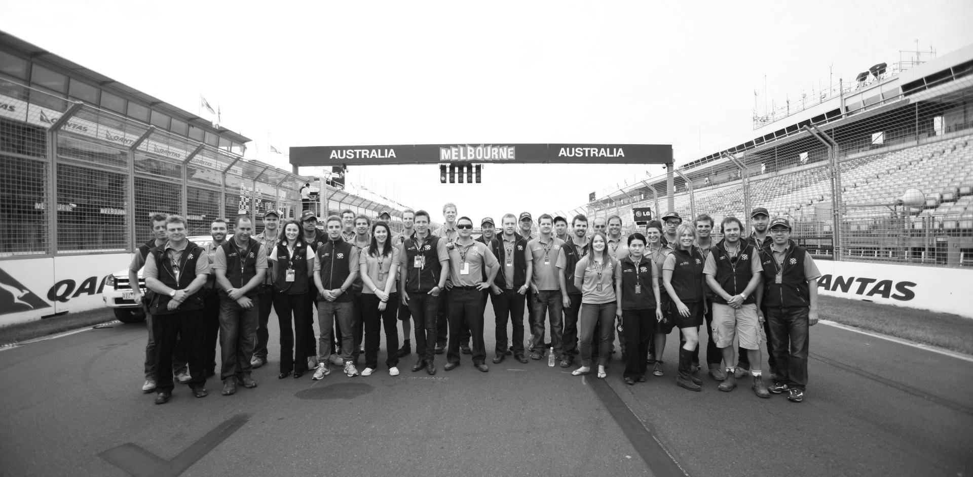 Black and white photograph of APP employees on the race track at the Melbourne Formula 1 Grand Prix