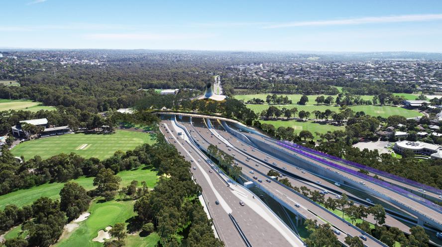 Overhead photograph of a highway and bridge running over the top on a sunny day