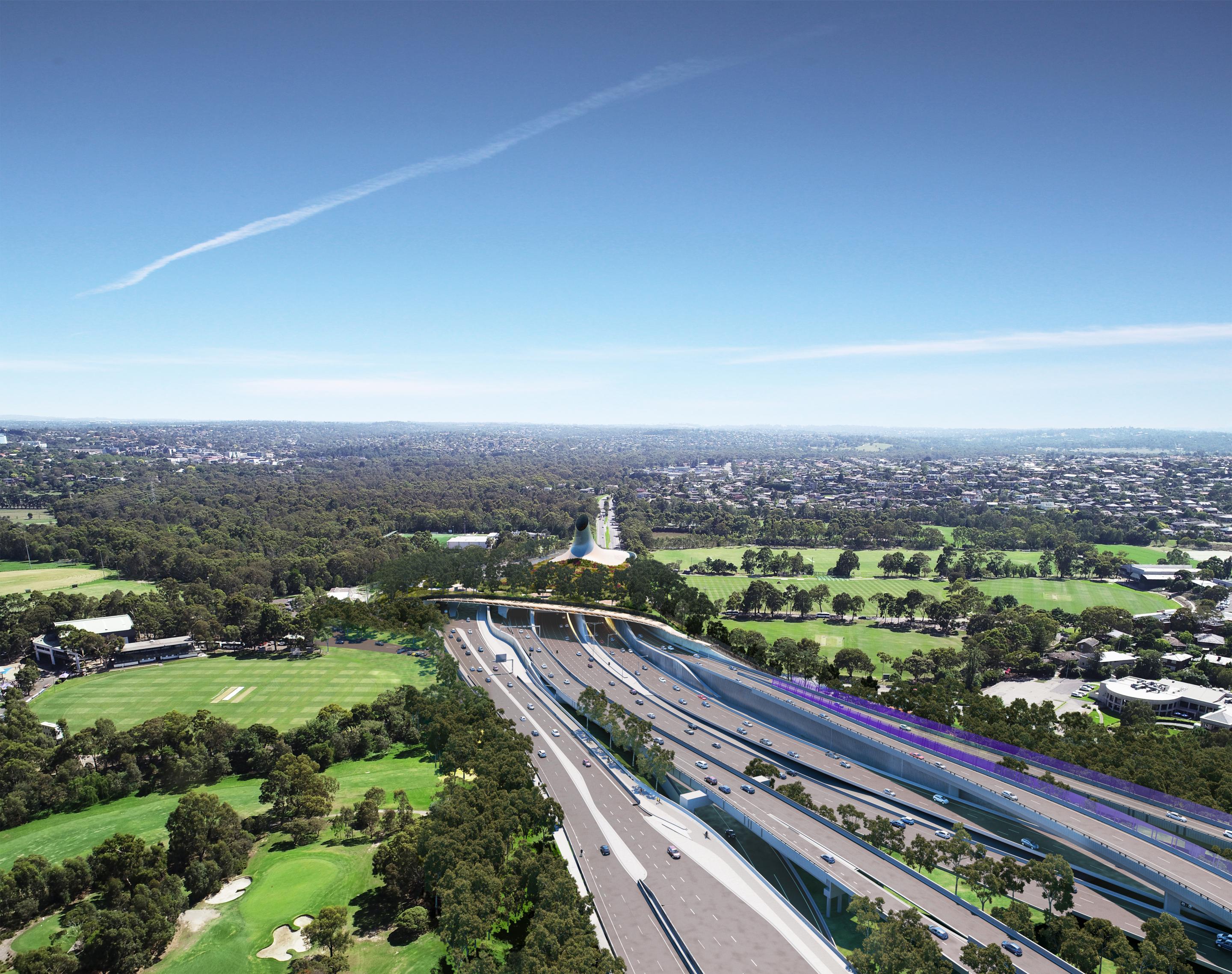 Overhead photograph of a highway and bridge running over the top on a sunny day