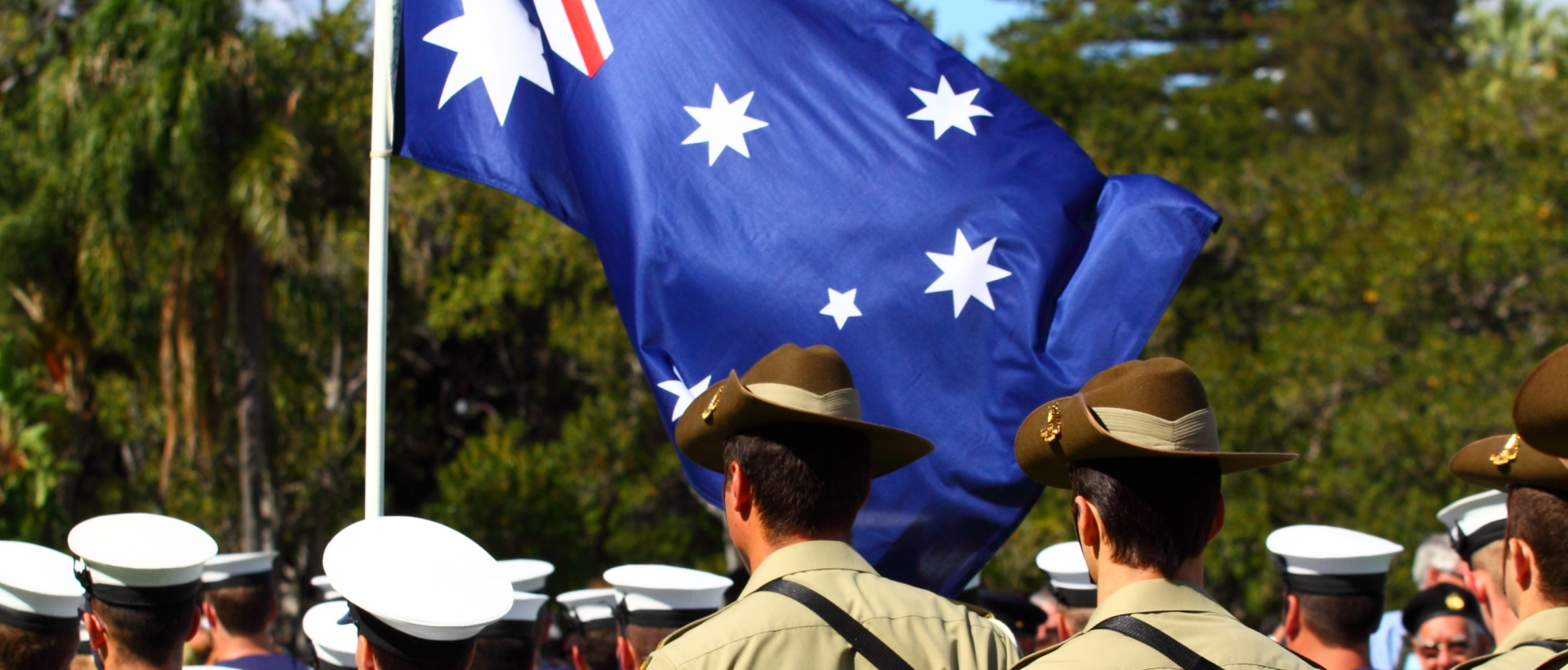 Army and navy colleagues marching with Australia flag