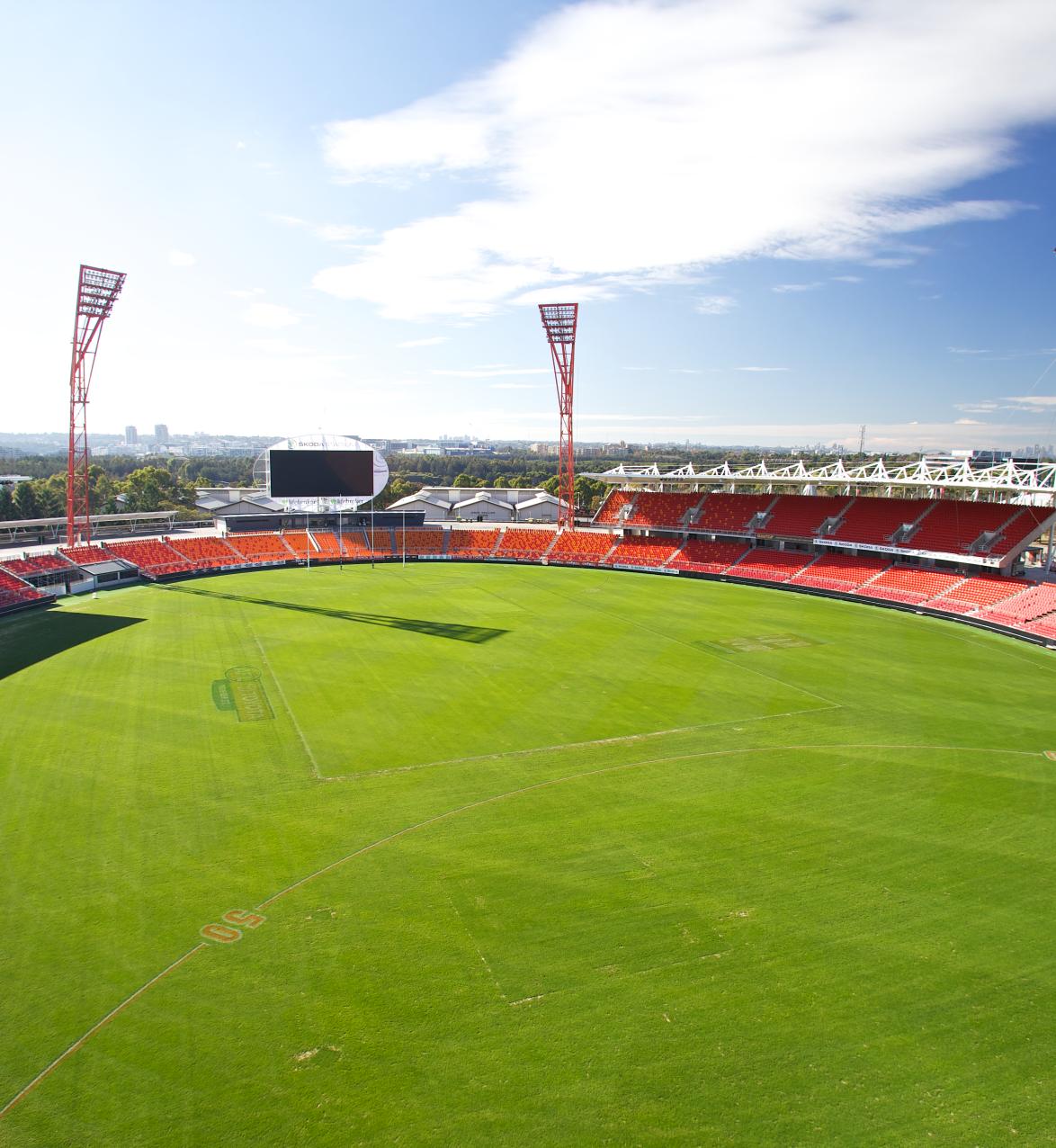 Interior view of large stadium with red grandstands and floodlights