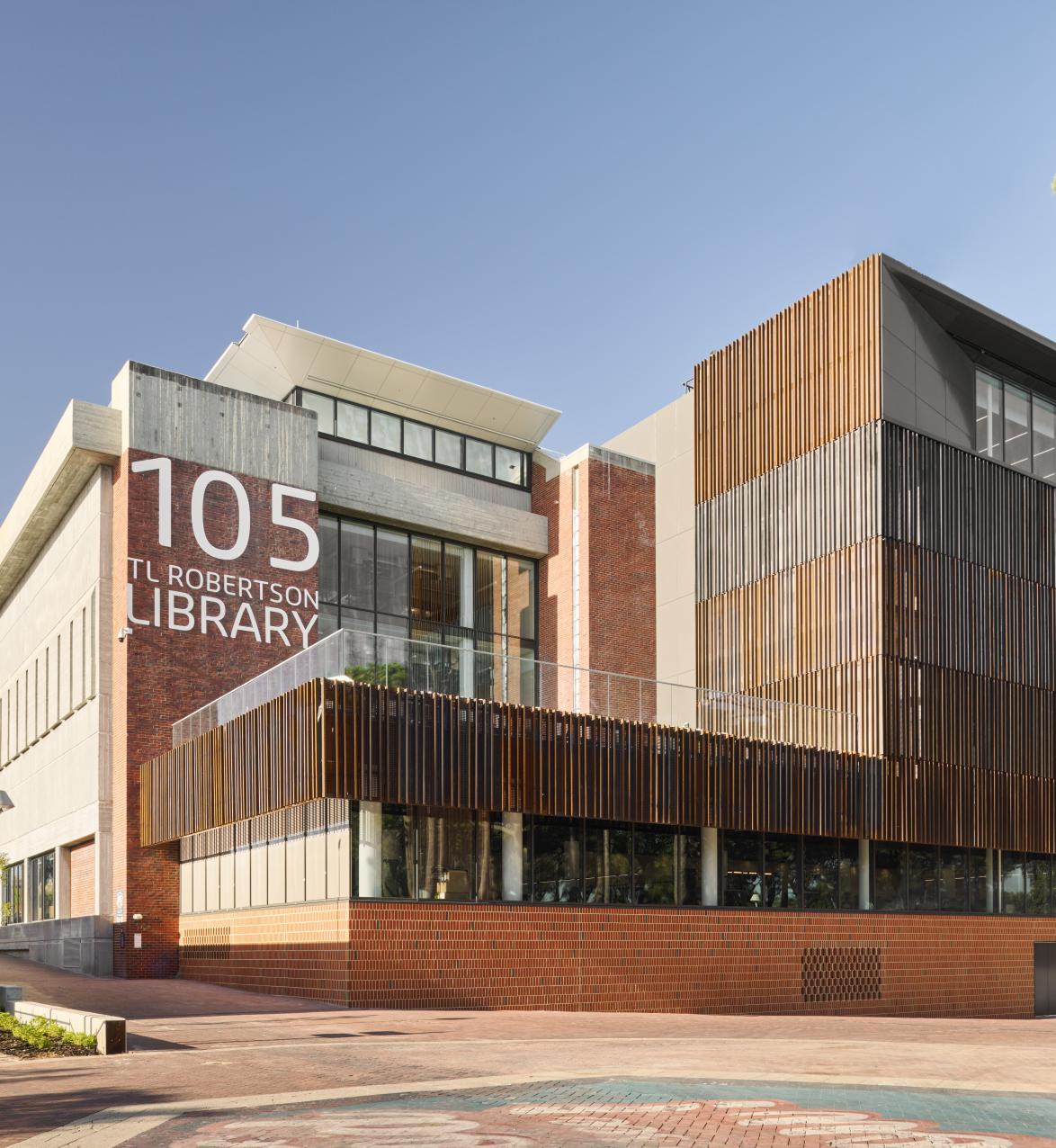 Exterior view of brown brick library building wit 105 TL Robertson Library written on the front